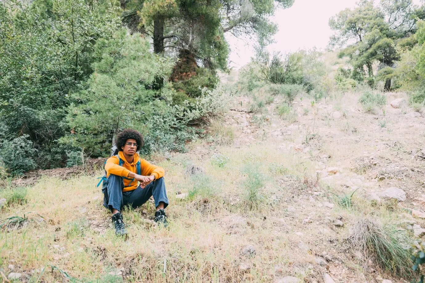 Ein Wanderer sitzt in der Natur.